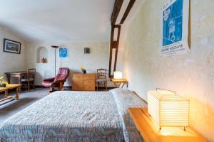 a bedroom with a bed and a desk and chairs at Studio Tamburine Xaharra in Ainhoa