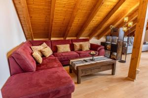 a living room with a red couch and a coffee table at Ferienwohnung Auf dem Hohen in Hüfingen