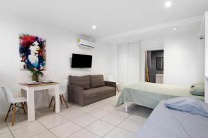 a bedroom with a bed and a couch and a table at Mi Casa Es Su Casa Nº1 in Albufeira