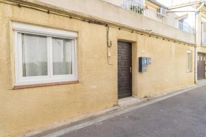 a brown building with a window and a door at Bel appartement 3 piece in Saint-Hippolyte
