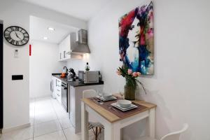 a kitchen with a table and a painting on the wall at Mi Casa Es Su Casa Nº1 in Albufeira
