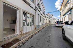 a street with cars parked on the side of buildings at Central Studio – Flor De Sol in Tavira