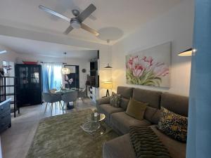 a living room with a couch and a ceiling fan at Bungalow Aloe Dunas in Maspalomas