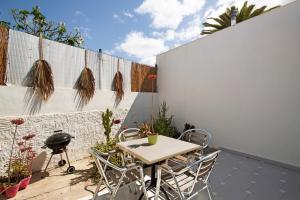 a patio with a table and chairs and a fence at Bungalow Aloe Dunas in Maspalomas