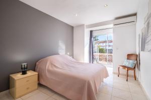 a bedroom with a bed and a window and a chair at Courtille sur Mer - port de Frejus in Fréjus +18 photos