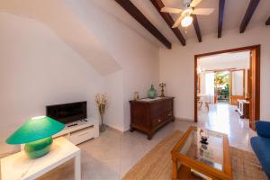 a living room with a blue couch and a tv at Villa Ca Sa Padrina in Santanyi