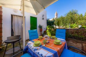 a table with blue chairs and an umbrella at Villa Ca Sa Padrina in Santanyi