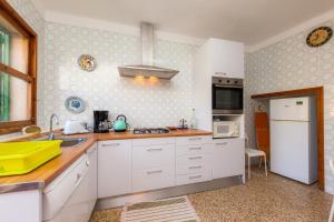 a kitchen with white cabinets and a yellow appliance at Villa Ca Sa Padrina in Santanyi +23 photos