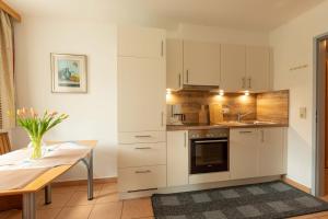 a kitchen with white cabinets and a wooden table at Appartment Isabelle Terra in Lake Pressegg
