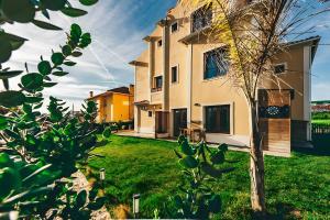 a house with a tree in the yard at Drop In Beach Apartments in Lourinhã