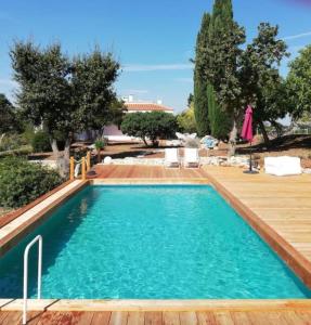 a swimming pool with a wooden deck and blue water at Villa Torto with private pool in Monopoli