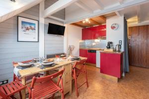 a kitchen with red cabinets and a table and chairs at Le Domaine du Lary in Saint-Lary-Soulan
