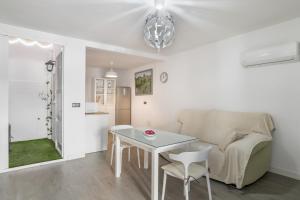 a white living room with a table and a couch at Apartamentos Serranía in Ronda +13 photos