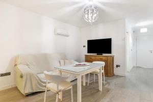 a living room with a white table and a tv at Apartamentos Serranía in Ronda