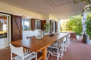 a dining room with a wooden table and chairs at Villa Torto with private pool in Monopoli