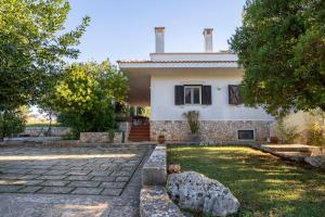 a house with a stone yard in front of it at Villa Torto with private pool in Monopoli