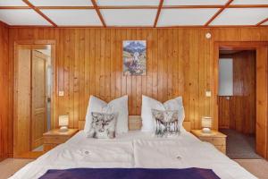 a bedroom with a bed with two cats pillows on it at Ferienwohnung Haus Eckhof in Wieden