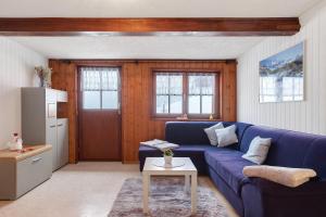a living room with a blue couch and a table at Ferienwohnung Haus Eckhof in Wieden