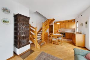 a kitchen and living room with a staircase and a table at Appartamento Al Pelmo a Vinigo in Vinigo