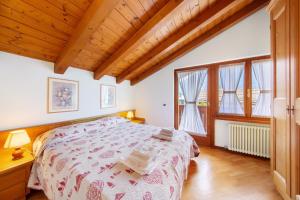 a bedroom with a bed and two windows at Appartamento Al Pelmo a Vinigo in Vinigo