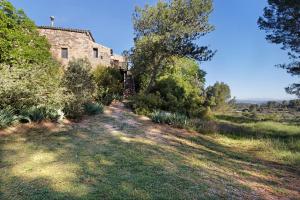 an old brick building in a field with trees at Cal Malla petit in Artés