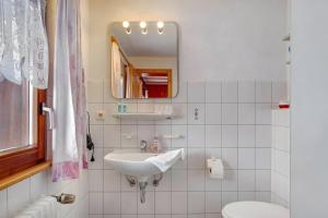 a bathroom with a sink and a toilet and a mirror at Ferienwohnung Haus Eckhof in Wieden +35 photos