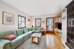 a living room with a green couch and a table at Appartamento Al Pelmo a Vinigo in Vinigo
