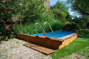 a swimming pool with a wooden deck around it at Cal Malla petit in Artés