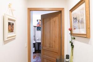 a hallway with a wooden door and a bathroom at Maison d'hotes Dolce Vita in Veyssilieu +20 photos