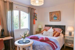 a bedroom with a bed with a table and a window at Maison d'hotes Dolce Vita in Veyssilieu