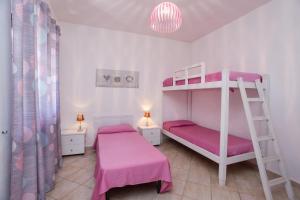 a bedroom with two bunk beds and a ladder at mirtagru casa dell'olivastro in Agrustos
