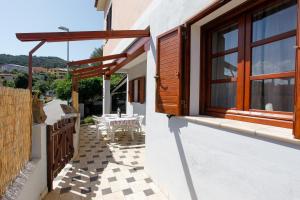 a patio of a house with a table and a window at mirtagru casa dell'olivastro in Agrustos
