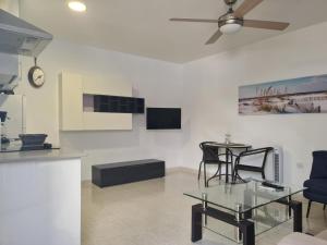 a living room with a ceiling fan and a table and chairs at Casa Paula - 22 in Arinaga