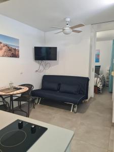 a living room with a blue couch and a table at Casa Paula - 22 in Arinaga