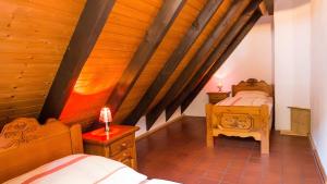 two beds in a room with wooden ceilings at Hohle Kirche in Hiltpoltstein