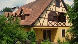a yellow house with a brown roof at Hohle Kirche in Hiltpoltstein