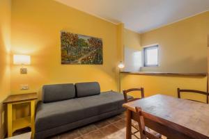 a living room with a couch and a table at Rosaspina - Appartamento 5 in Capalbio