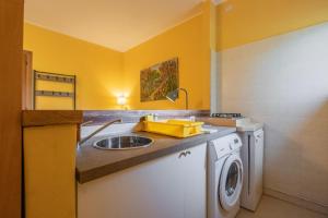 a kitchen with a sink and a washing machine at Rosaspina - Appartamento 5 in Capalbio