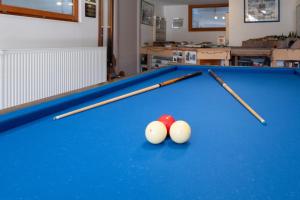two cue sticks and two balls on a pool table at Le Chalet des Beuquillons in Gérardmer