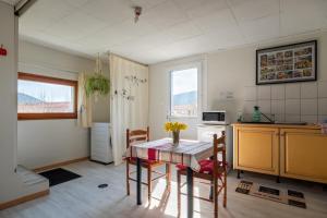 a kitchen with a table and chairs in a room at Le Chalet des Beuquillons in Gérardmer