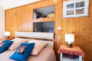 two beds in a room with wood paneled walls at Le Chalet des Beuquillons in Gérardmer