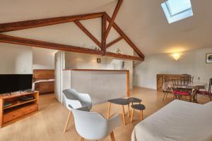 a living room with a table and chairs and a tv at Maison Dans Ancienne Forge in Noyarey