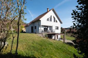 a white house on top of a grassy hill at Le Chalet des Beuquillons in Gérardmer