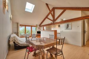 a kitchen and dining room with a wooden table and chairs at Maison Dans Ancienne Forge in Noyarey