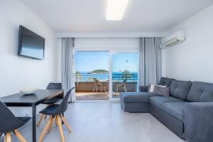a living room with a couch and a table at First Line Cosy Apartment in Calvià