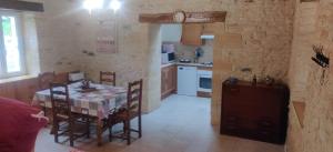 a kitchen with a table and chairs in a room at Terre De Pierres - Gite Améthyste in Saint-Geniès