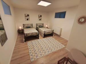 a room with two beds and a rug at Chambre Écureuil in L'Ile-Bouchard