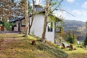 a white house with a tree and chairs in the yard at Auszeyt Edersee für Vier in Waldeck