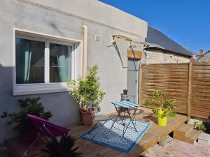 a patio with a table and chairs and a window at Chambre Écureuil in L'Ile-Bouchard