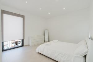a white bedroom with a bed and a window at Gc Luxury Apartments e Spa in Santa Margherita di Belice